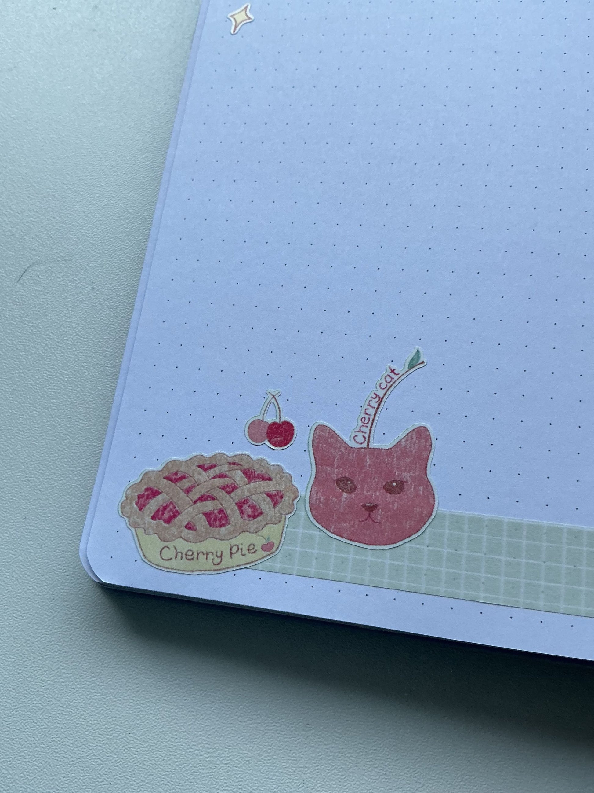 Notebook with cherry pie and cat illustration on a white background